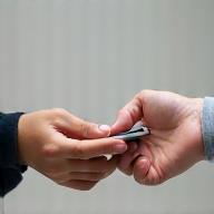 Hand receiving a repaired smartphone from a technician